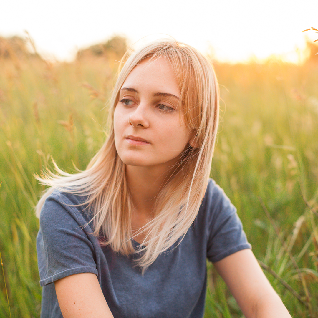 Young woman outside thinking about her pregnancy